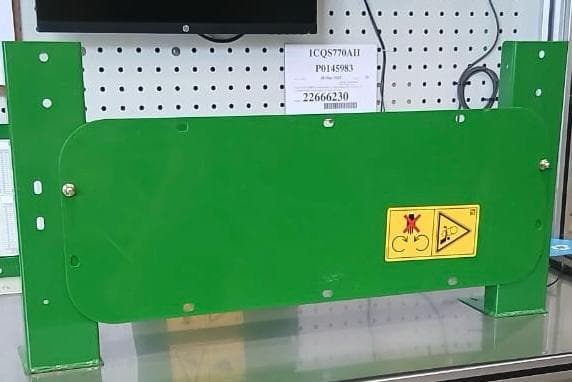 Peça verde com o adesivo de segurança sendo verificado